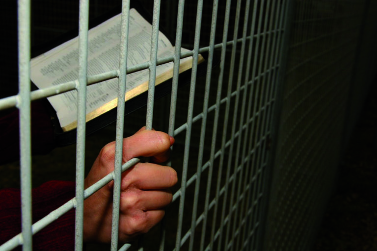 Un prisonnier lit la Bible dans sa cellule