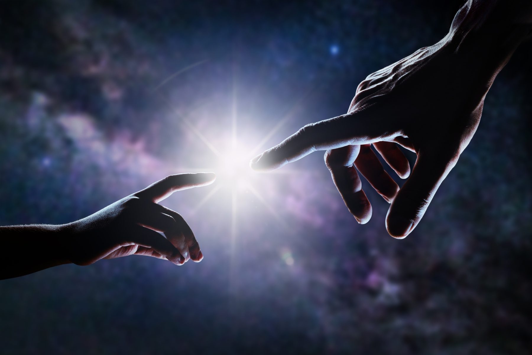 Gros plan de deux mains, adulte et enfant, se rejoignant comme dans la peinture de Michel-Ange devant les étoiles et la galaxie. La lumière brille entre les doigts du père et du fils.