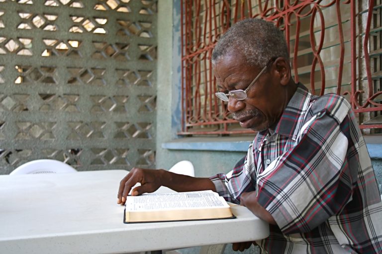 Un homme lisant sa Bible depuis sa terrasse