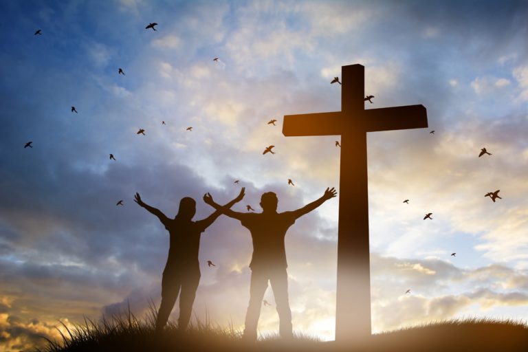 Une famille célébrant Dieu au pied d'une croix