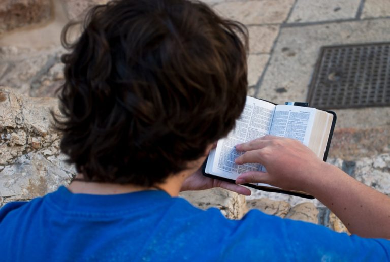 Jérusalem, Israël - 11 août 2006: pèlerin lisant le livre du Deutéronome devant l'église du Saint-Sépulcre