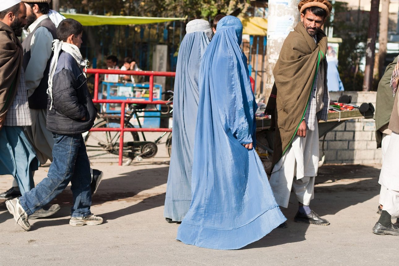 Un homme afghan avec ses deux femmes dans les rues de Fayzabad, Afghanistan