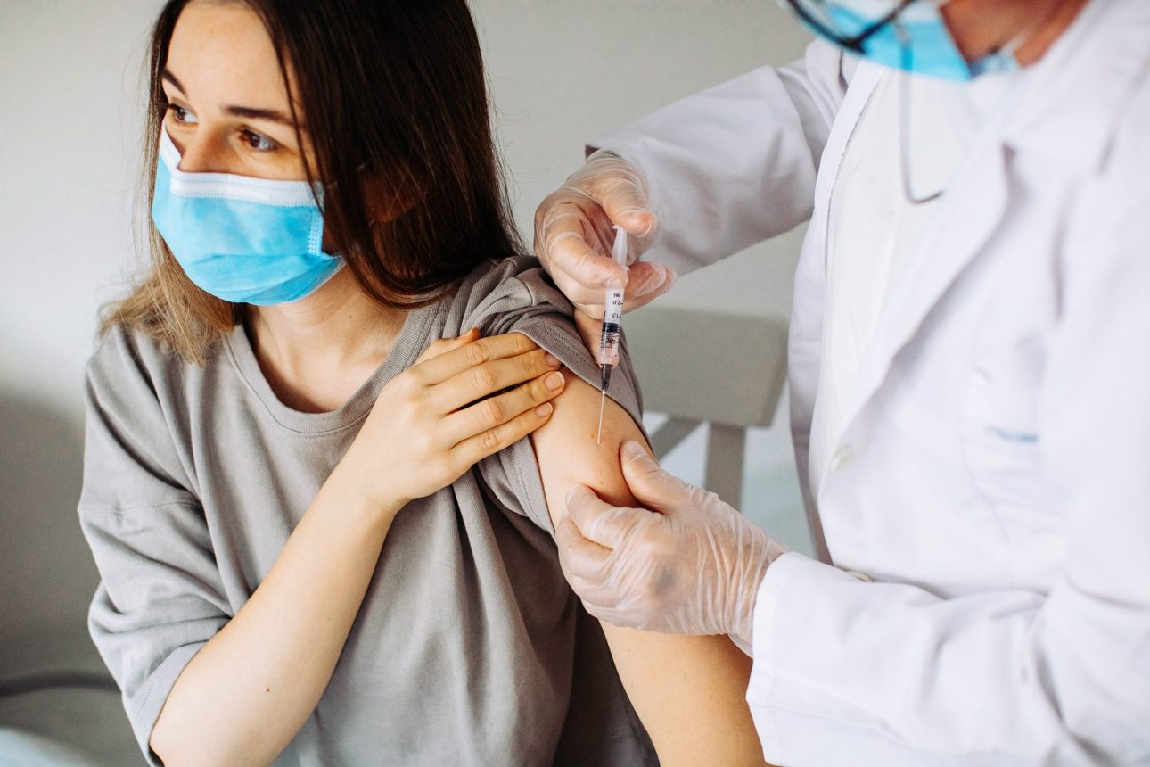 Jeune femme avec masque facial se faisant vacciner, coronavirus, covid-19 et concept de vaccination