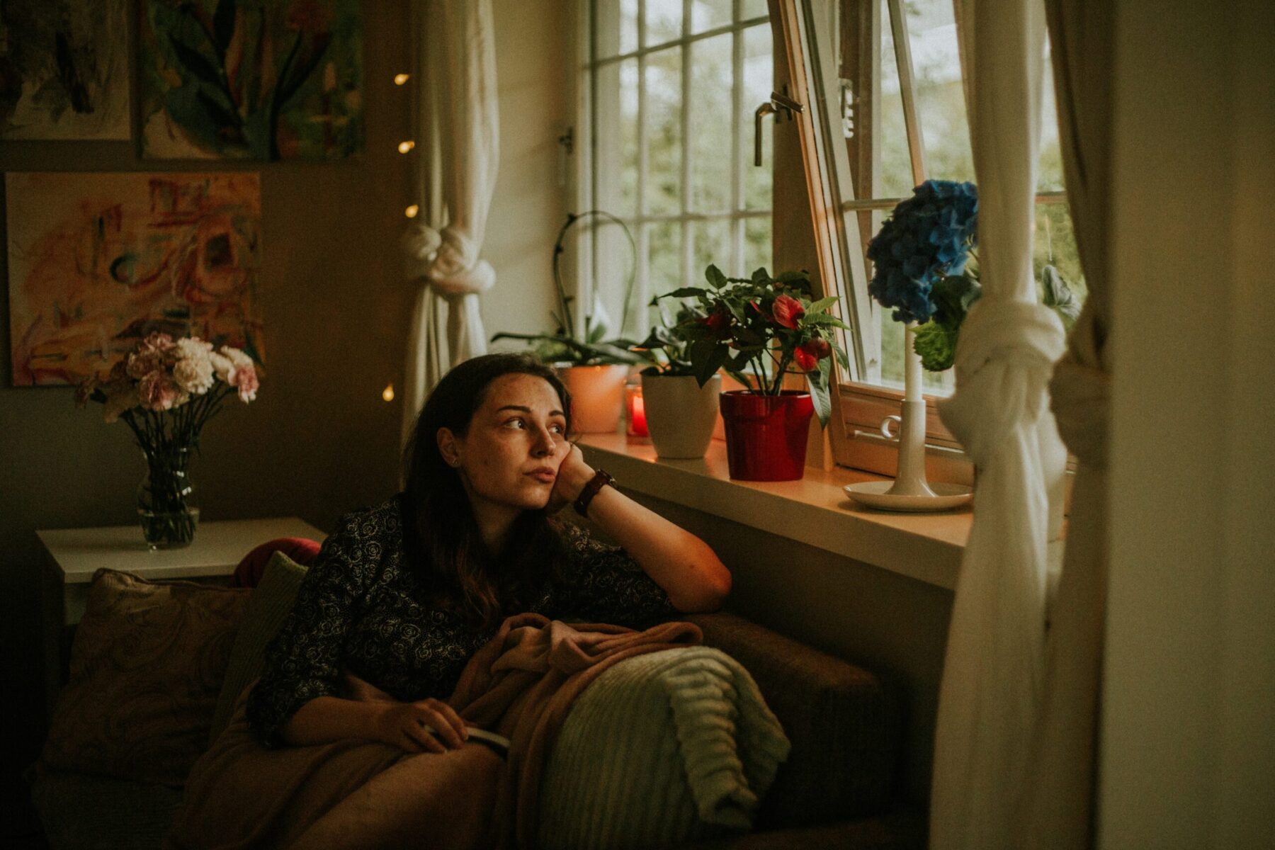 Femme seule regardant par la fenêtre, illustrant la solitude des conjoints de pasteurs
