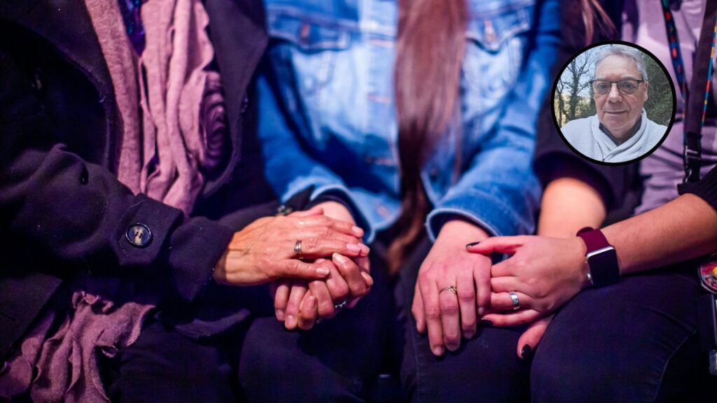 Deux personnes tiennent la main d'une troisième en signe de soutien.