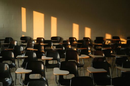 Rangée de chaises vides dans une salle de cours, symbolisant la baisse des inscriptions en théologie