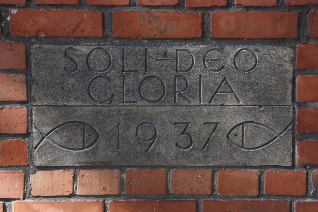 Plaque en pierre avec deux ichthys gravés et l'inscription «Soli Deo Gloria 1937»