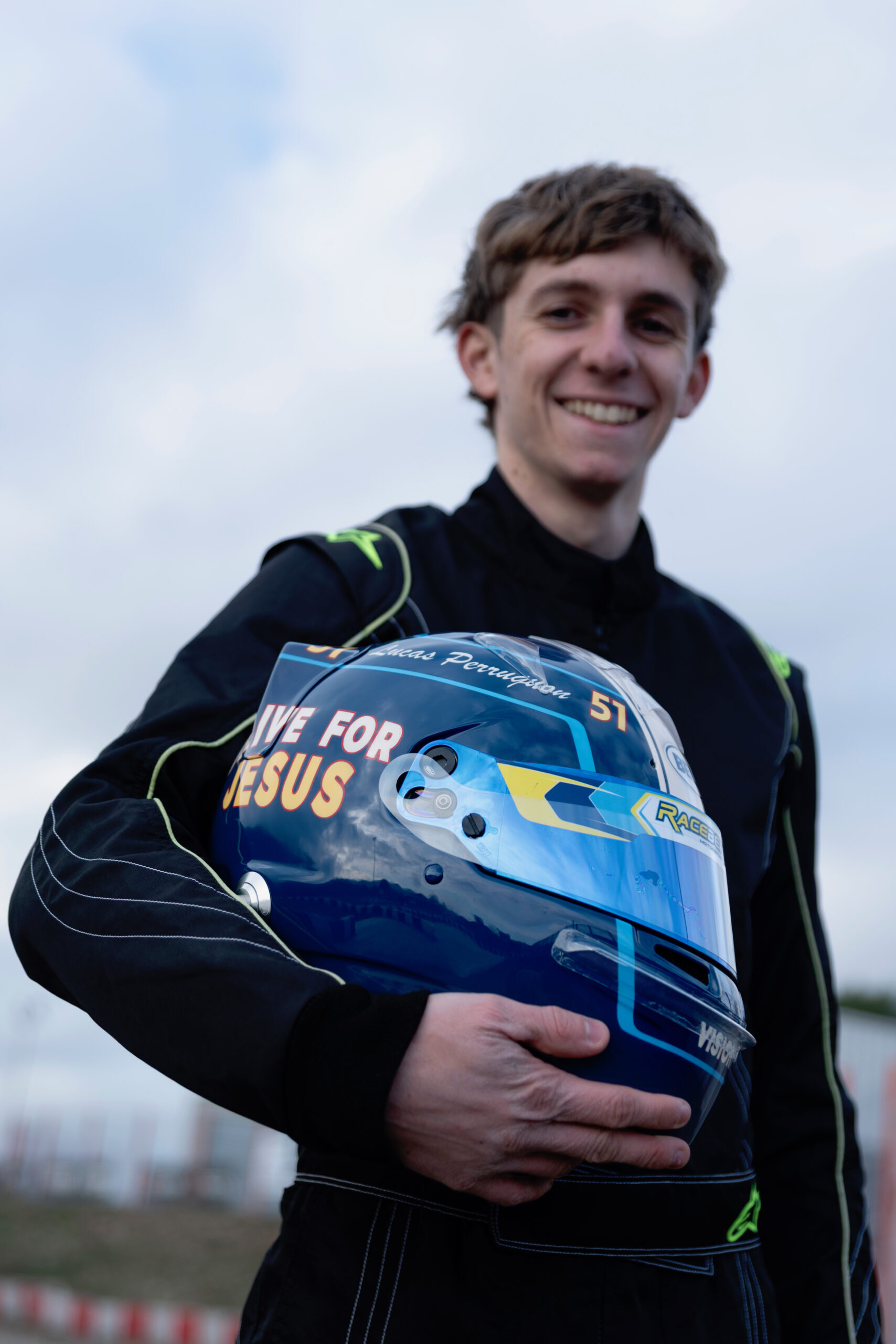 Lucas Perruquon, jeune pilote de karting, tenant son casque marqué «Drive for Jesus»