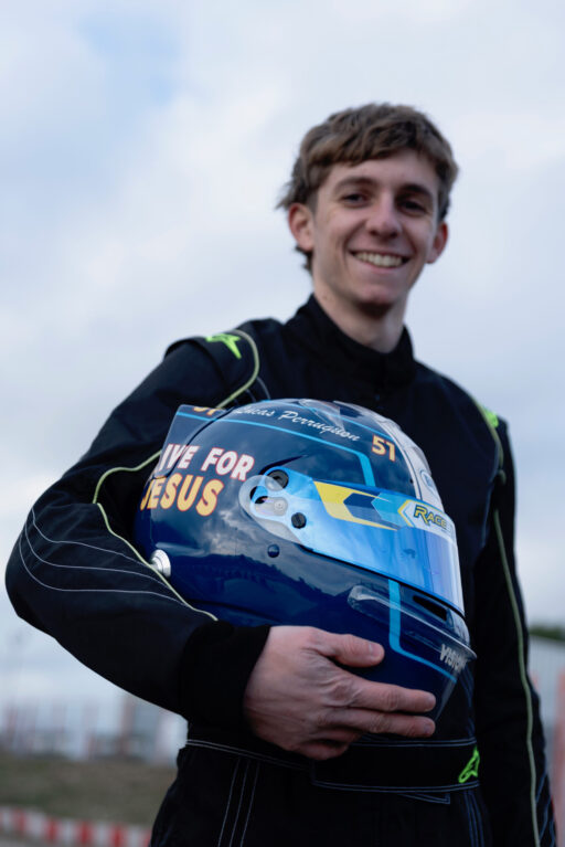 Lucas Perruquon, jeune pilote de karting, tenant son casque marqué «Drive for Jesus»