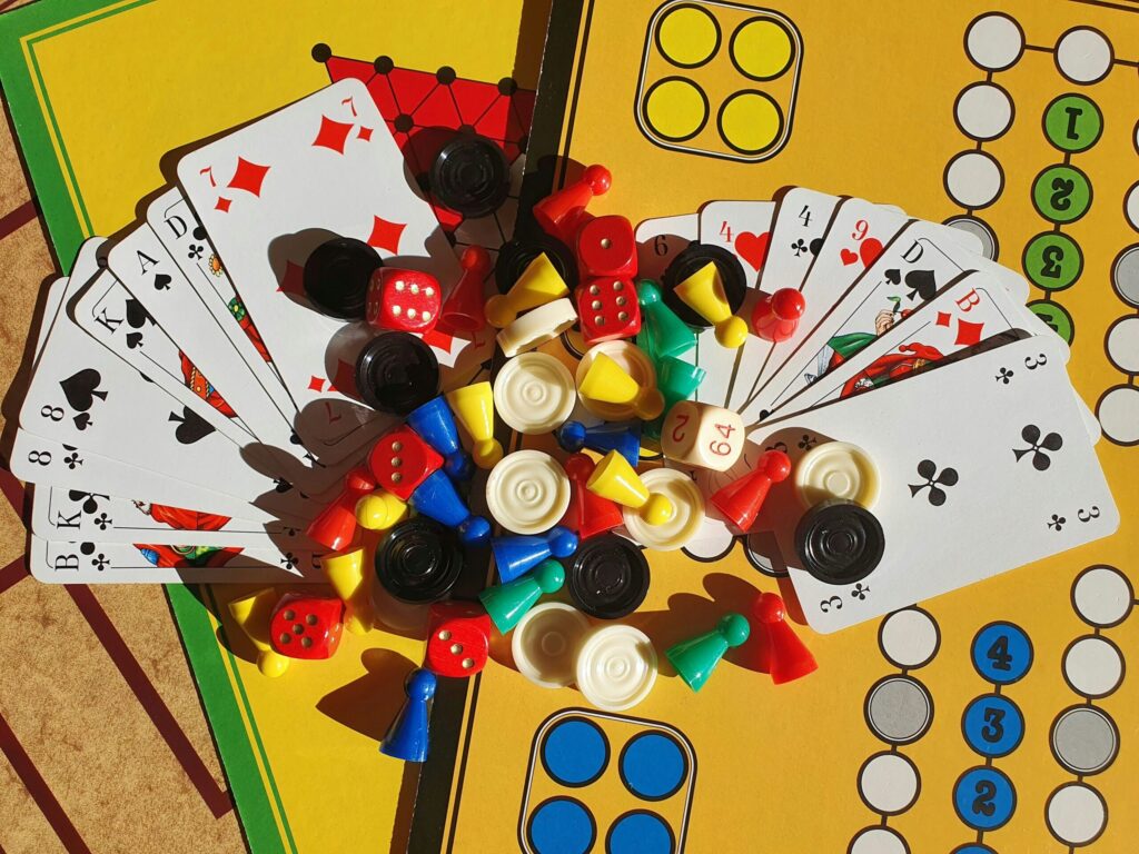 Plateau de jeu, cartes, dés et pions colorés vus de dessus