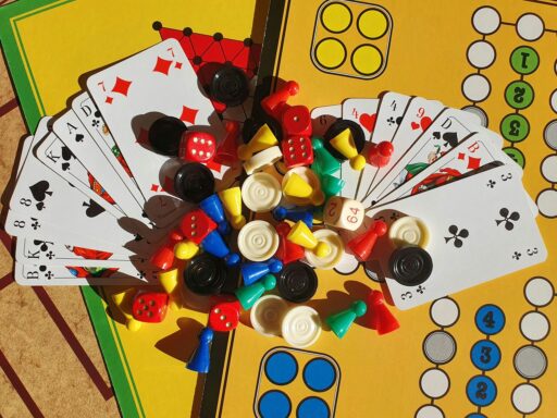 Plateau de jeu, cartes, dés et pions colorés vus de dessus