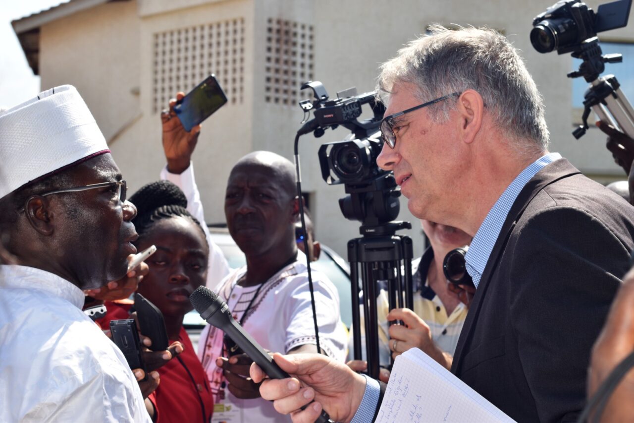 Serge Carrel, micro à la main, en reportage
