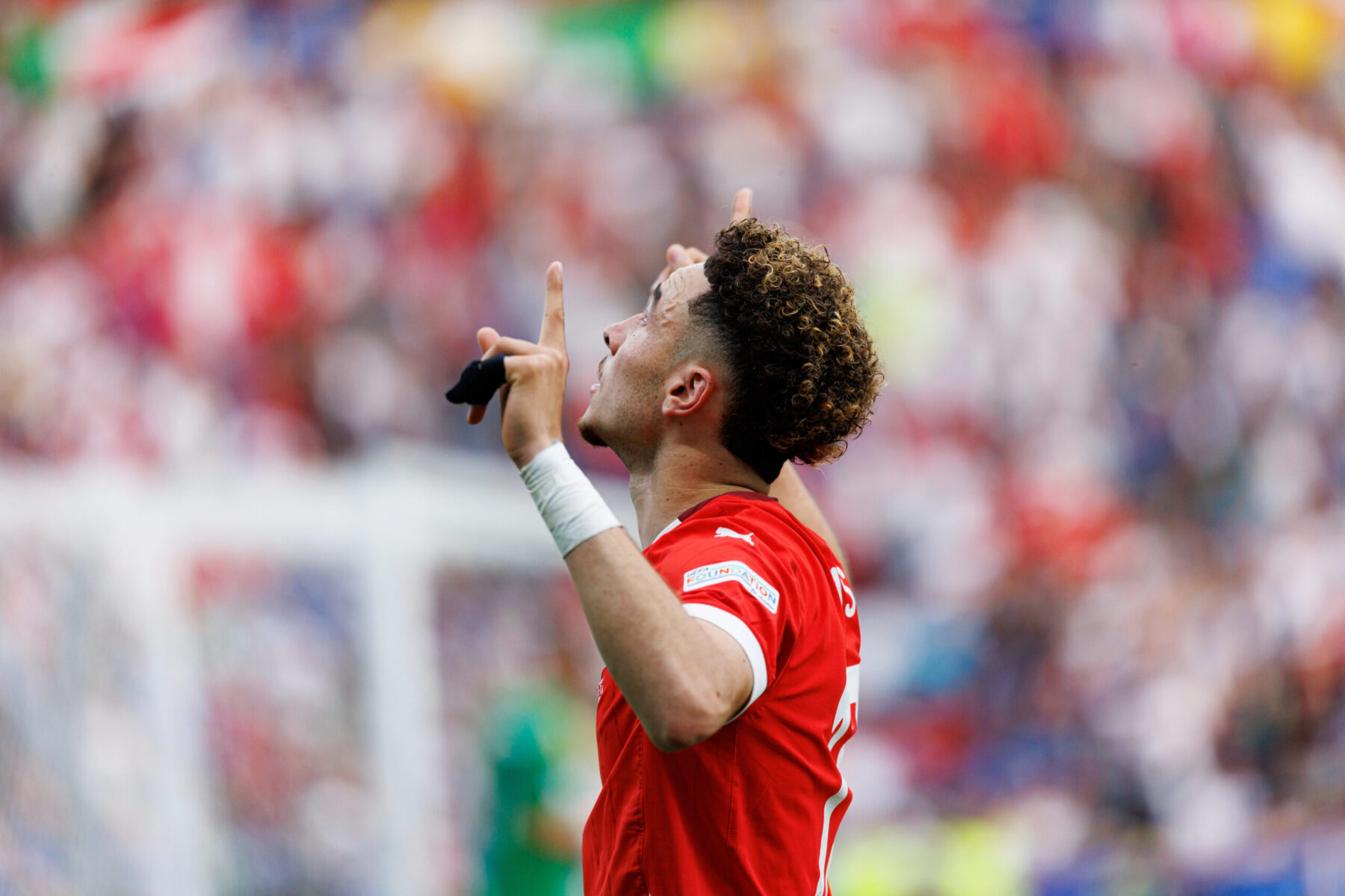 Le footballeur suisse Rubén Vargas célébrant un but, doigts pointés vers le ciel