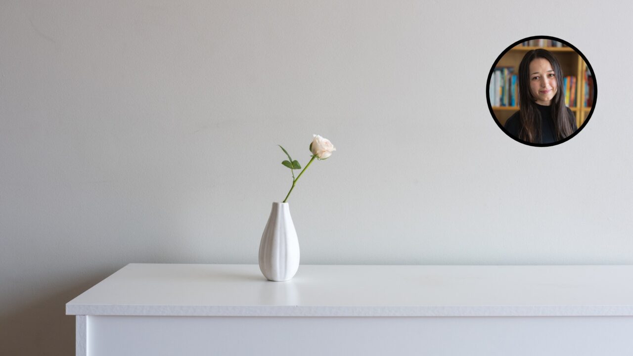 Une seule fleur dans un vase sur un meuble, symbolisant la simplicité