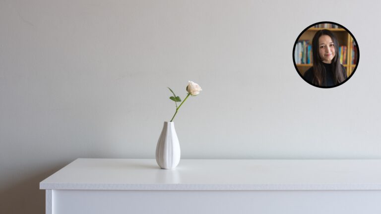 Une seule fleur dans un vase sur un meuble, symbolisant la simplicité