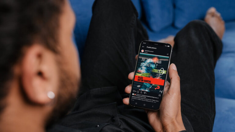 Main tenant un smartphone affichant un fil Instagram